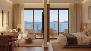Habitación de hotel con un balcón amplio, una cama, una zona de estar con mesa y sillas, y vistas al mar.