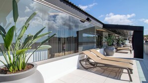 A rooftop terrace with potted plants, sun loungers, and a clear view of the sky. - Golden Port Salou & Spa (Salou)