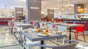 Un restaurante moderno con varias mesas, sillas y una zona de bufé.
