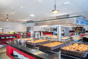 A buffet area with various food items and a seating area with tables and chairs.