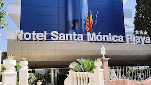 De ingang van Hotel Santa Mónica Playa, met een opvallend blauwe gevel en vlaggen.