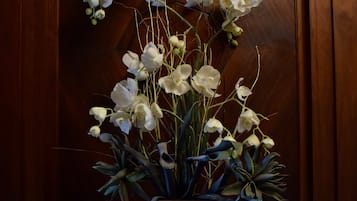 A bouquet of white orchids in a vase on a wooden surface.