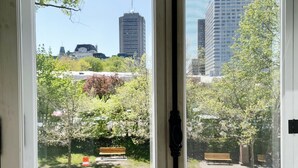 A view through a door with a cityscape, including buildings and trees. - Le Manoir d'Auteuil - Par Aneyro (Québec City)