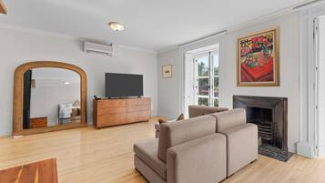 Deluxe Studio | Living area | 50-inch flat-screen TV with cable channels, TV, books