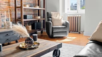 Leilighet – grand | Oppholdsområde | En 50-tommers Flatskjerm-TV med kabel-kanaler samt TV og bøker