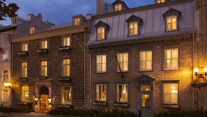 A historic building with multiple windows and a well-lit entrance. - Le Manoir d'Auteuil - Par Aneyro (Québec City)