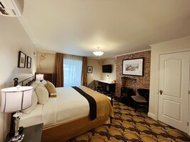 Une chambre d’hôtel avec un lit, une table de chevet, une lampe et une cheminée.