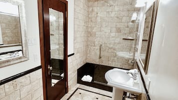 Un baño moderno con un espejo grande, un lavabo y una zona de ducha.