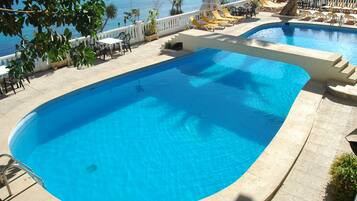 Een buitenzwembad en ligstoelen