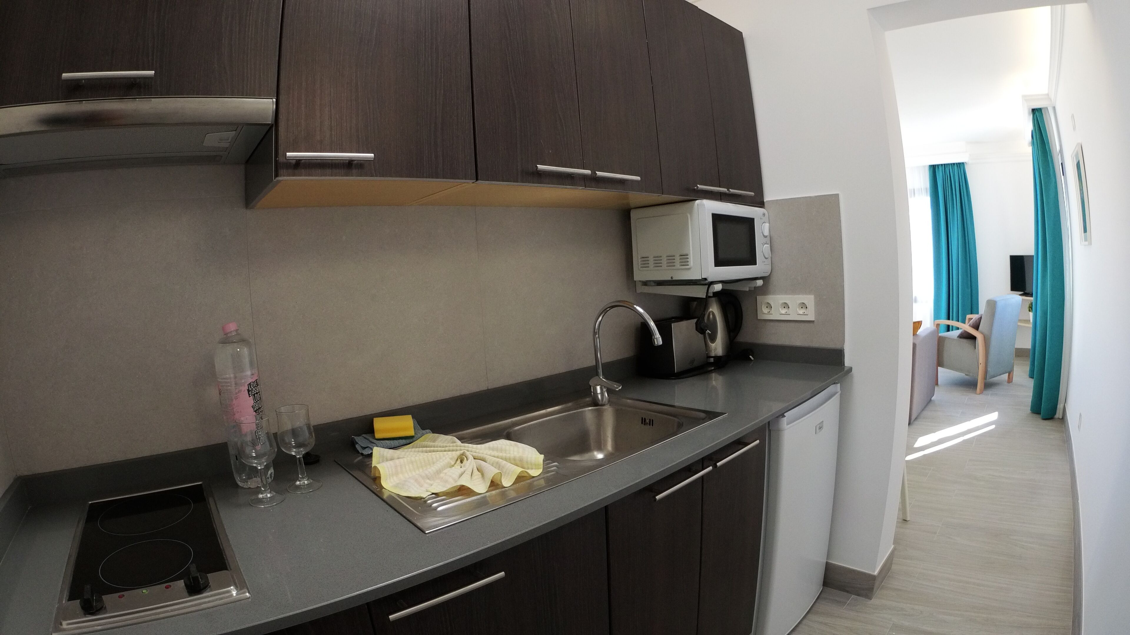 Una cocina moderna con microondas integrado, un fregadero y una estufa.
