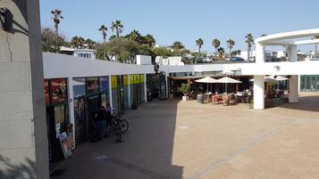 Un patio con zona de café, mesas al aire libre y una tienda Planet Bikes.