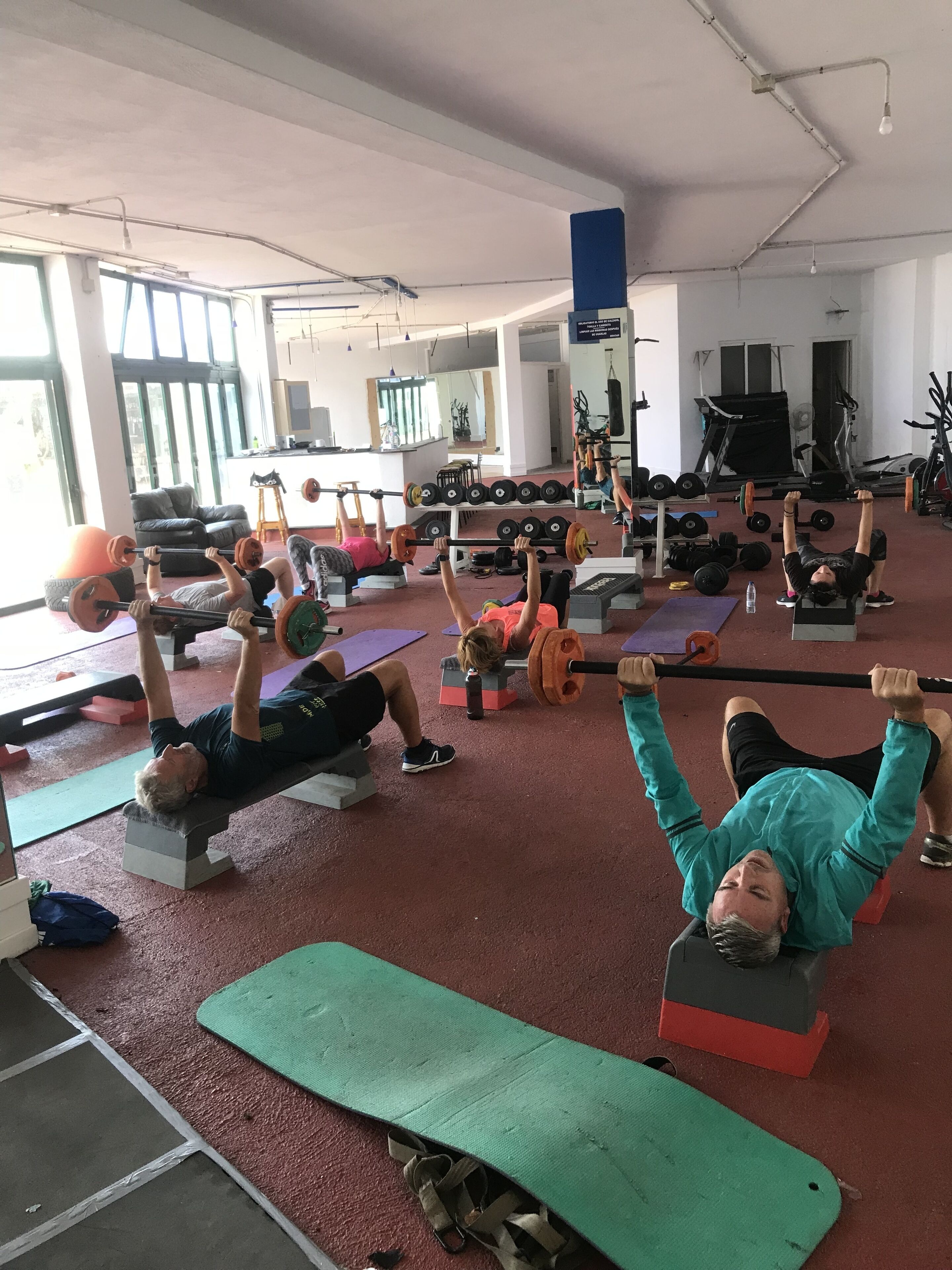 A gym with various exercise equipment and mats.