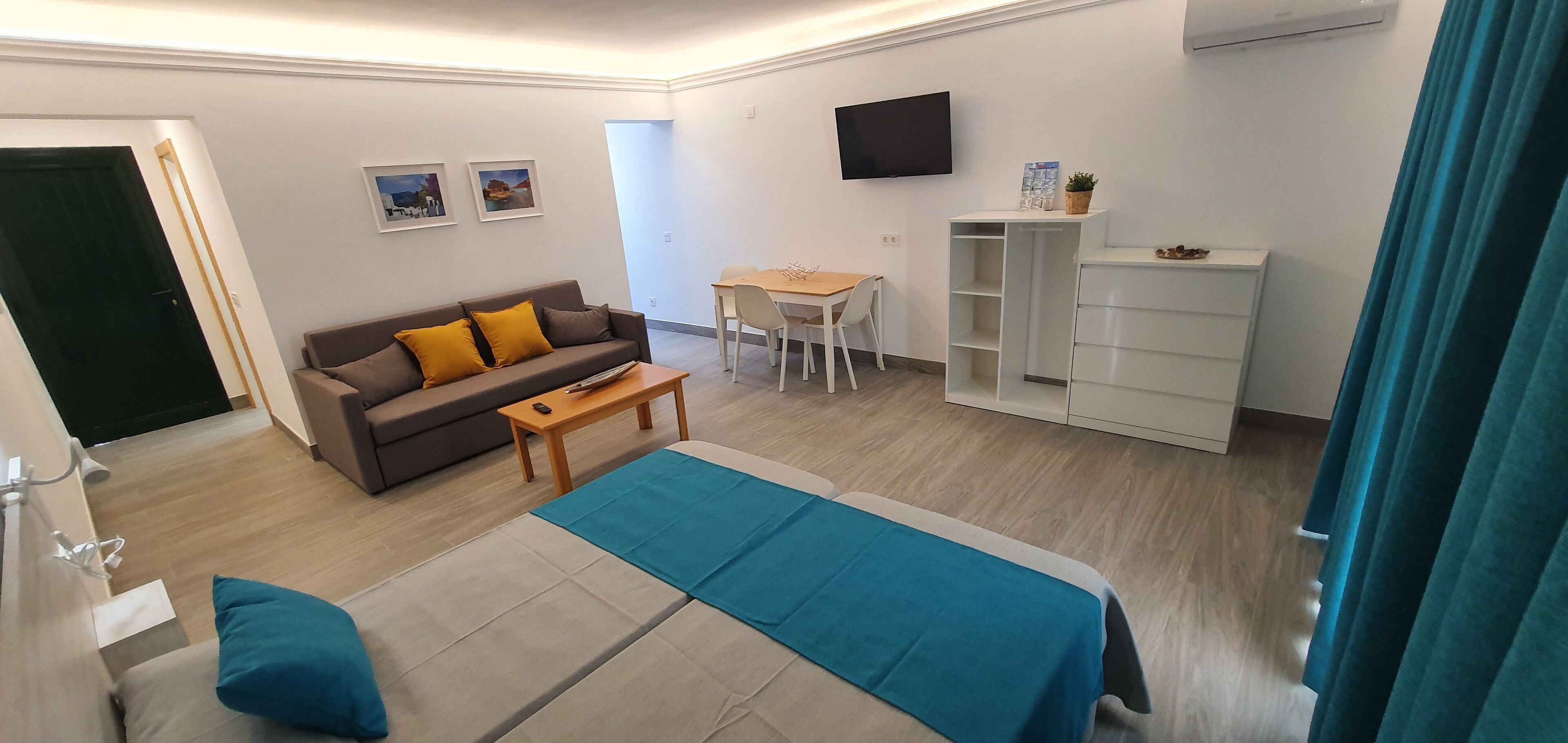 Una habitación de hotel moderna con cama, sofá, escritorio y televisor.