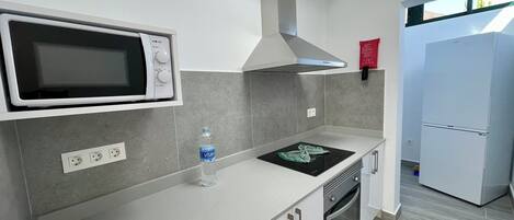 A modern kitchen with a built-in microwave, stove, oven, and a refrigerator.