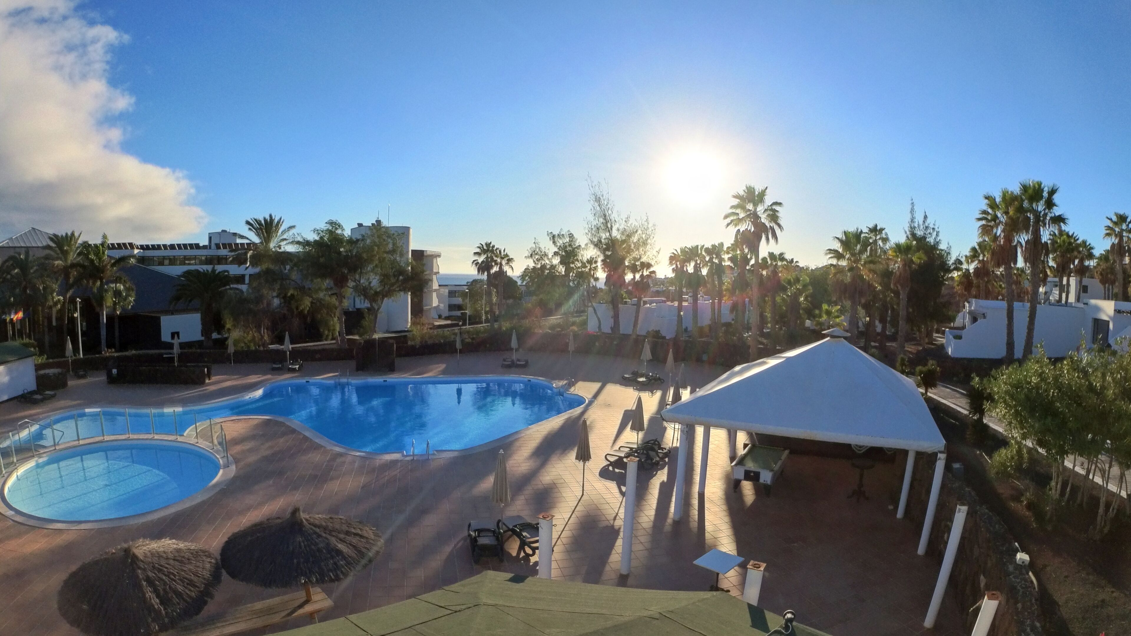 Alberca al aire libre, sombrillas en la alberca y camastros 