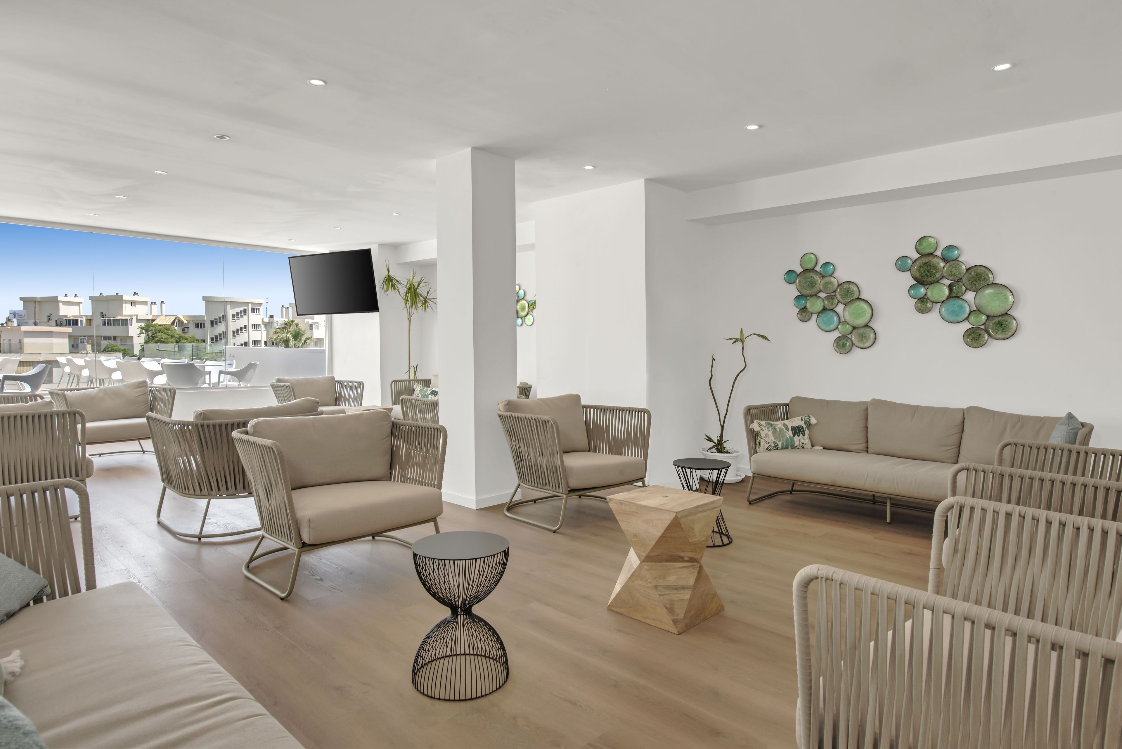 Een moderne woonkamer met een bank, stoelen, een salontafel en decoratieve wandkunst.