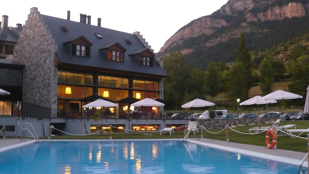 A hotel with a pool, outdoor seating, and mountain views. - Aparthotel Hg Cerler (Benasque)
