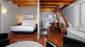 A hotel room with a wooden ceiling, a bed, a desk, a chair, and a staircase. - Aparthotel Hg Cerler (Benasque)