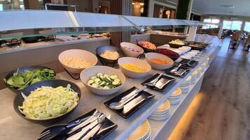 A buffet with various food items and utensils.