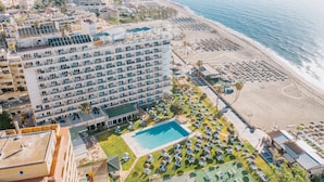 A hotel with multiple floors, a swimming pool, and a beach area with sun loungers. - Hotel La Barracuda (Torremolinos)