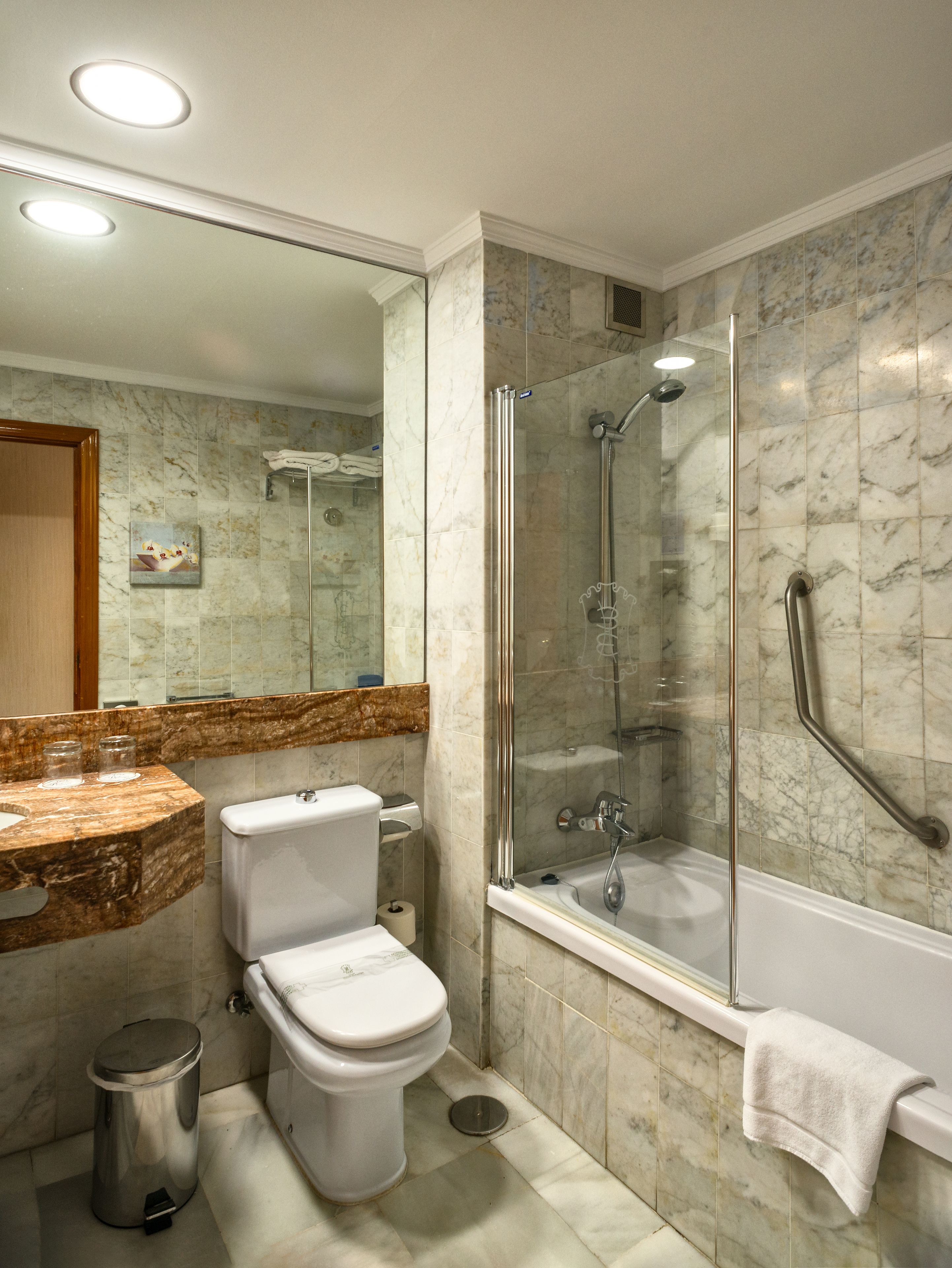 Un baño con inodoro, lavabo y ducha.