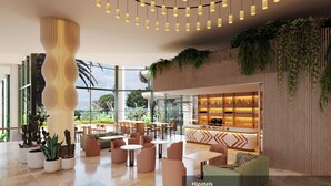 A modern hotel lobby with a bar area, seating arrangements, and a large window offering a view of the outdoors.