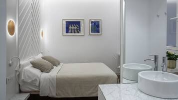 Una camera da letto moderna con un letto, un comodino e due opere d'arte appese al muro.