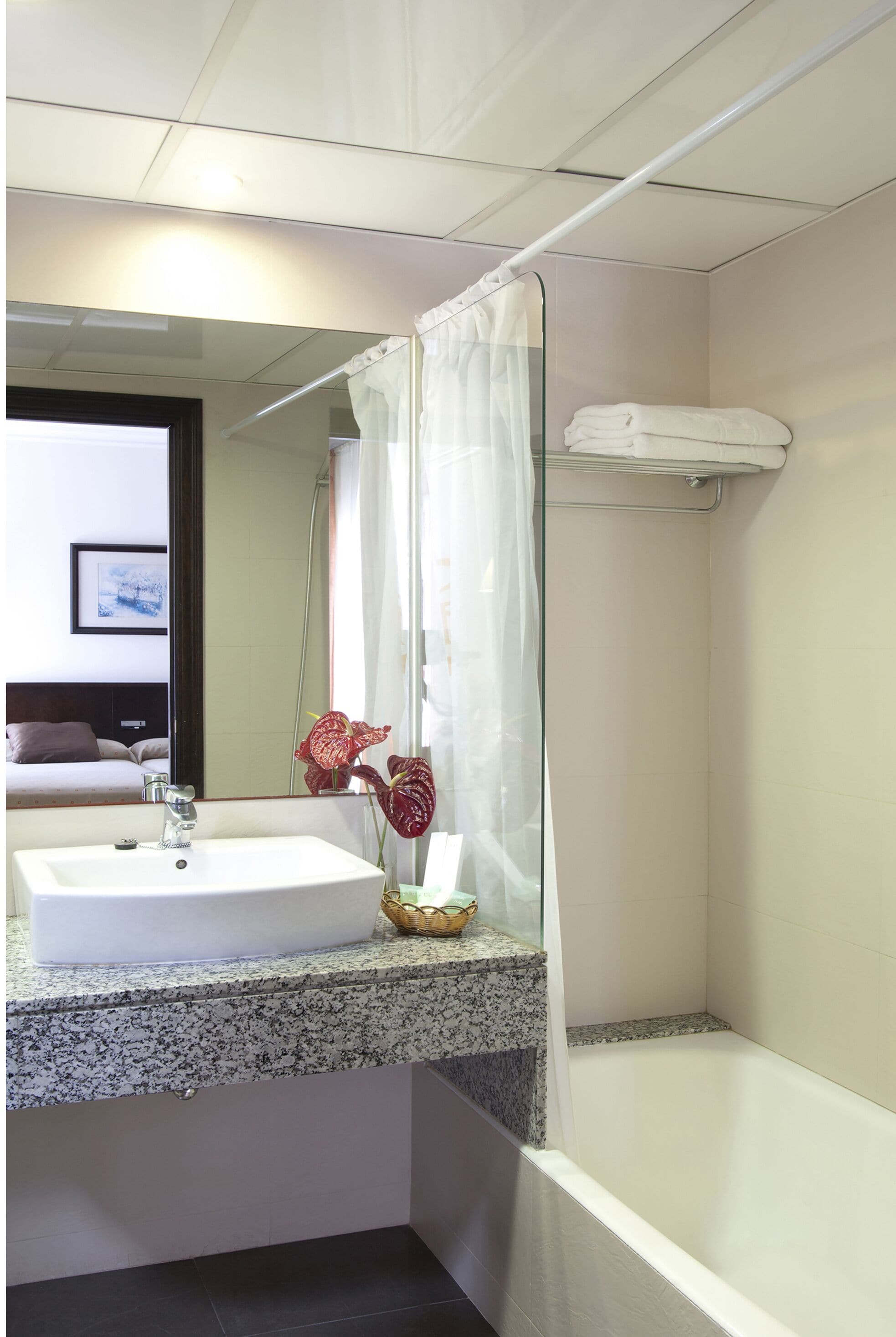 A bathroom with a white sink, a glass shower enclosure, and a white bathtub.