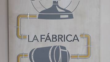 A wall with a logo and text that reads "Cruzcampo ORIGEN LA FÁBRICA EN TU BAR".