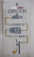 A wall with a logo and text that reads "Cruzcampo ORIGEN LA FÁBRICA EN TU BAR".
