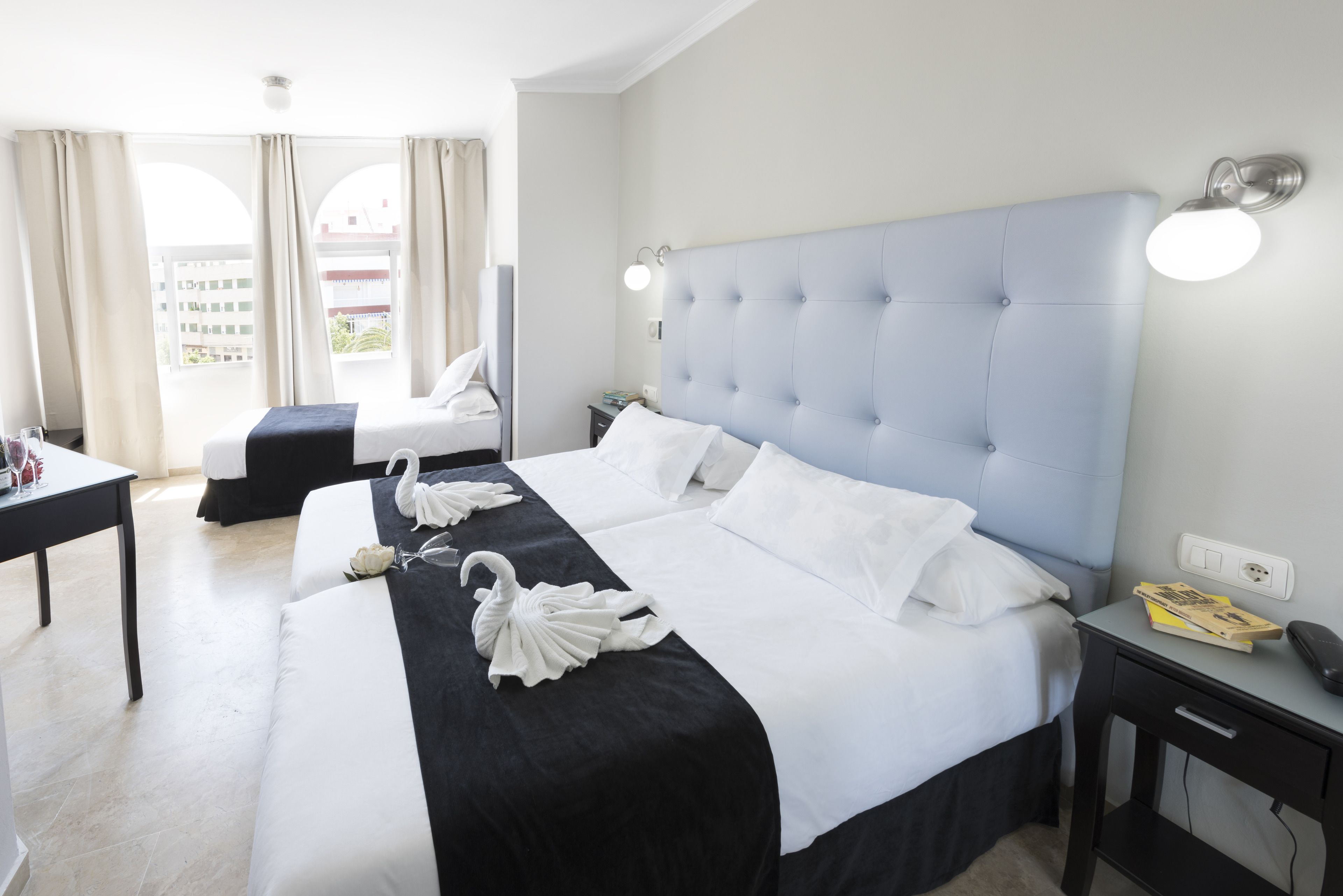 Une chambre d’hôtel avec un grand lit, un bureau et une chaise.
