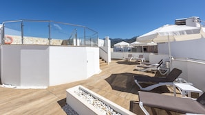A rooftop terrace with sun loungers, a pool, and a clear view of the mountains. - Hotel Toboso Chaparil (Nerja)