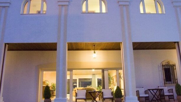 A building with a covered patio area, columns, and a seating arrangement with tables and chairs. - La Luna Blanca (Torremolinos)