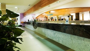 A reception area with a marble counter, wooden ceiling, and potted plants. - Hotel Monarque Fuengirola Park (Fuengirola)