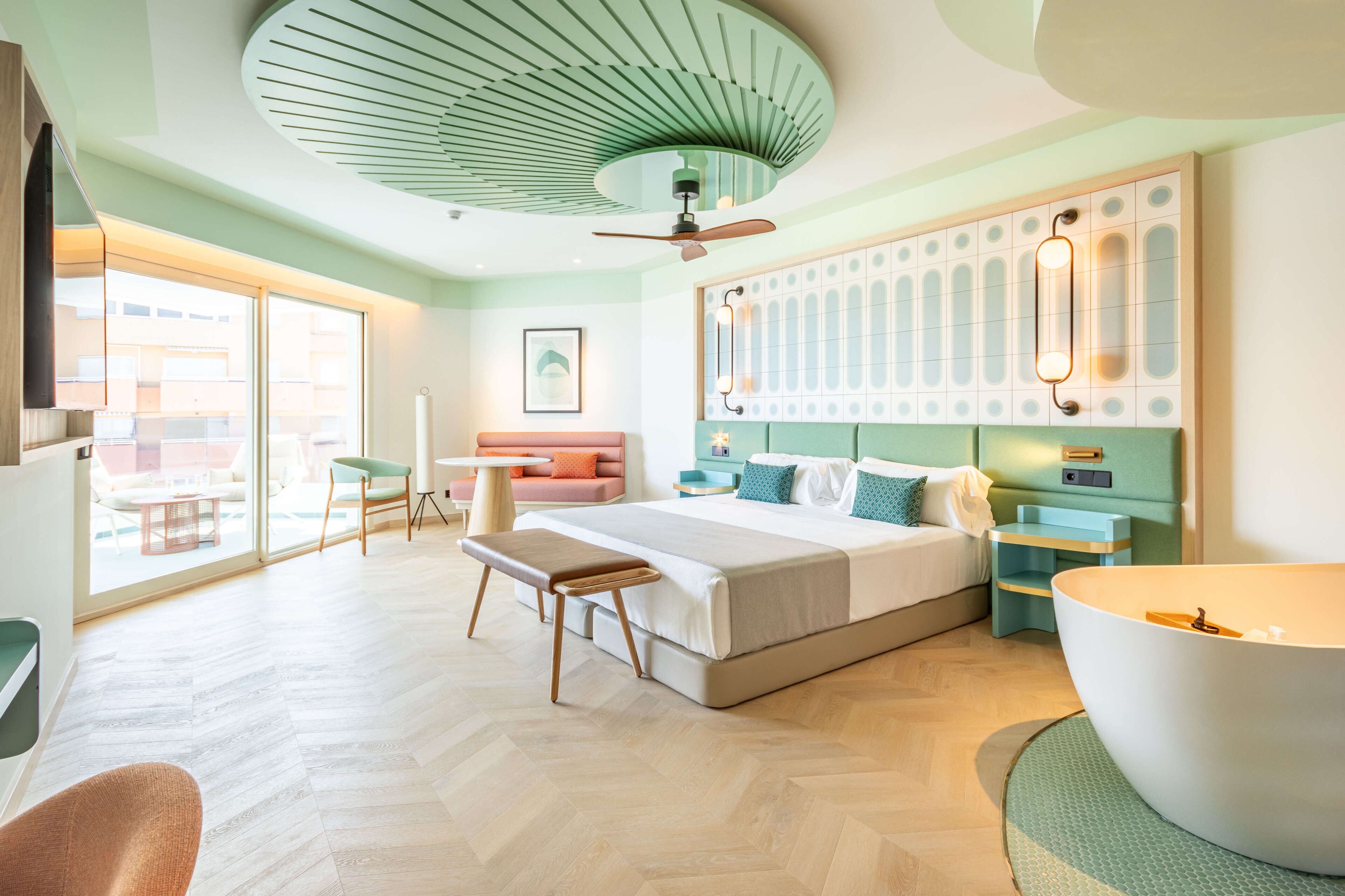 Een moderne hotelkamer met een groot bed, een zithoek, een eettafel en uitzicht.