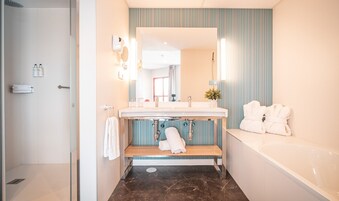 Une salle de bain moderne avec une baignoire, un lavabo et un miroir de coiffeuse.
