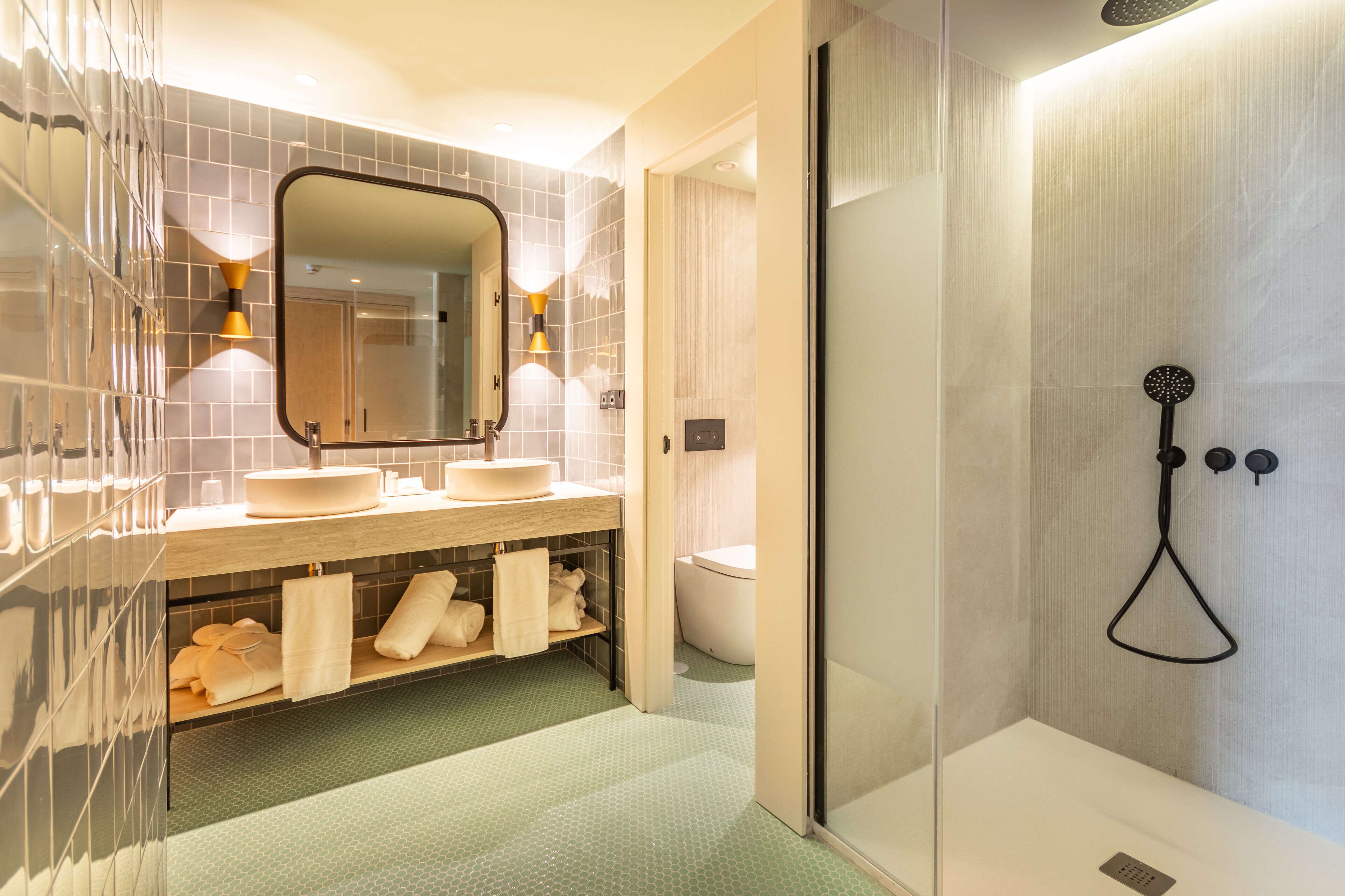 A modern bathroom with a glass-enclosed shower, a vanity with a mirror, and a toilet.