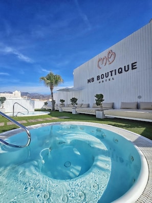 Experience the serene atmosphere of MB Boutique Hotel, where a large pool and comfortable outdoor seating area await.