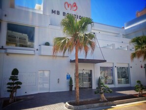 Welcome to MB Boutique, featuring a clean design with large windows and lush greenery.