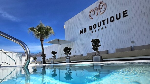 Una piscina con vistas al hotel MB Boutique al fondo.