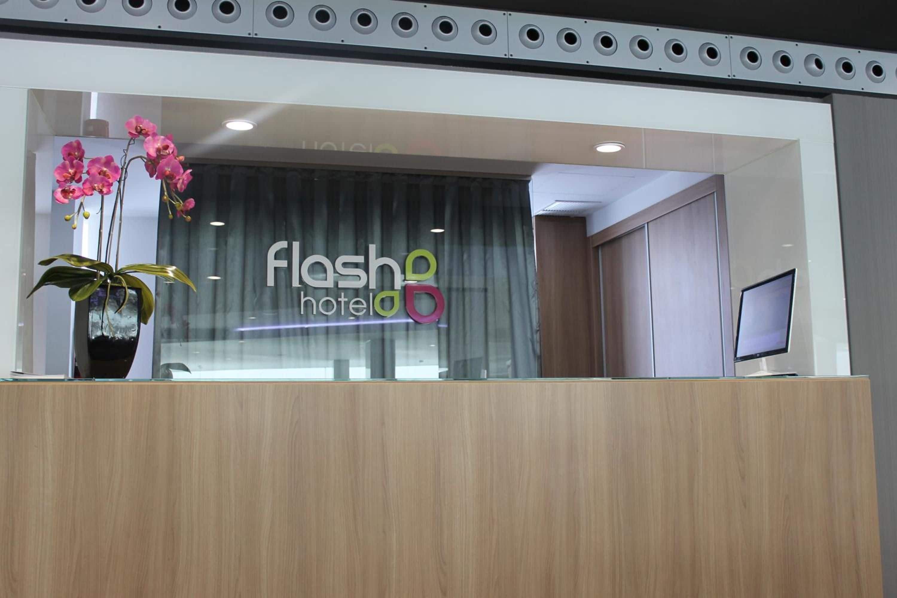 Een receptiebalie met een bordje waarop 'Flash Hotel' staat.
