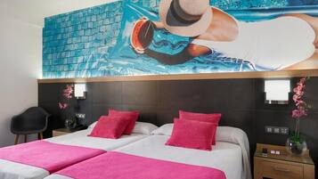 Habitación de hotel con un gran mural de una piscina, una cama con ropa de cama rosa y una mesita de noche con un florero.