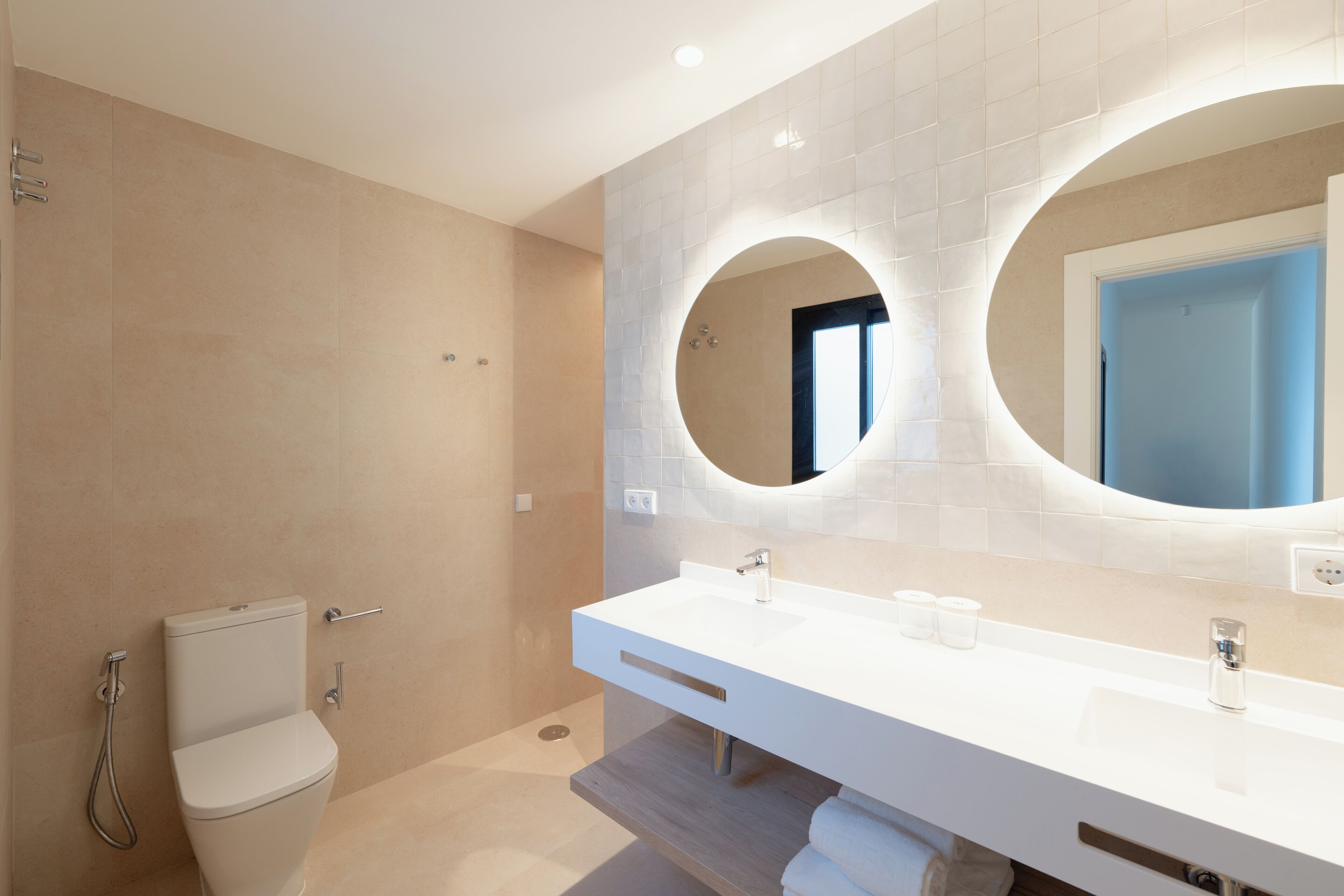 A modern bathroom with a toilet, a sink, and a shower.