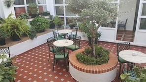 Relax in a serene outdoor space surrounded by lush greenery and comfortable seating.