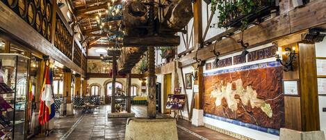 A historic building with wooden beams, a large stone centerpiece, and a map mural.