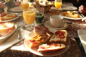 A breakfast setting with plates of toast, fruit, and a cup of coffee. - Hotel Tudanca Aranda II (Fuentespina)