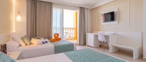 Habitación de hotel con dos camas, un escritorio, un televisor y un balcón con una silla.