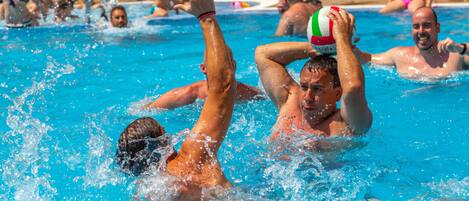 Una piscina con gente jugando con una pelota.