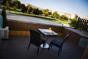 An outdoor patio with a table and chairs, a plate of food, and a glass of orange juice. - Los Braseros Hotel (Burgos)