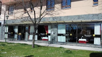 A hotel with a 'HOTEL' sign above the entrance, a 'BRASEROS' sign on the windows, and a 'BRASEROS' sign on the facade.